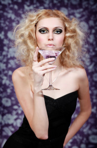 Beautiful woman with purple drink in martini glass